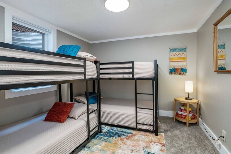 - Functional bunk room perfect for kids or groups looking to share the space comfortably
- Features two twin over twin metal bunk beds with cozy bedding & colorful throw pillows
