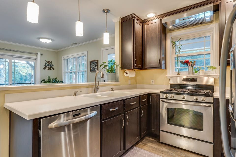 Dishwasher and bar top looking into dining area with lake view