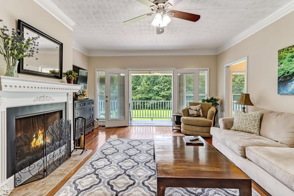 Living room leads out to wrap around porch and view of the yard