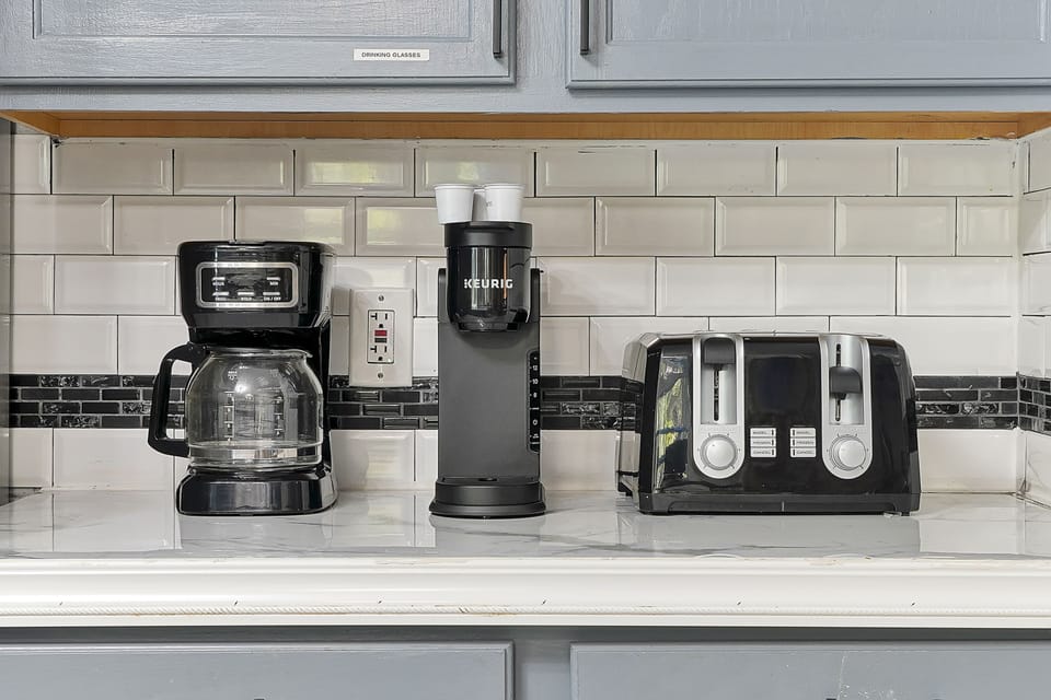 Keurig coffee maker, drip coffee maker, and toaster make this kitchen feel like home