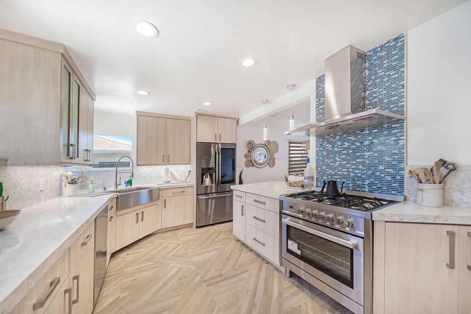 Kitchen with commercial grade stove/oven, vent hood and farmhouse sink.