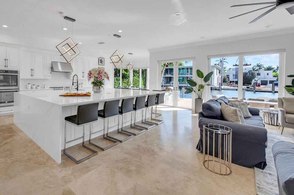 The family room with the open kitchen provides seamless access to the heated pool and features waterfront views.