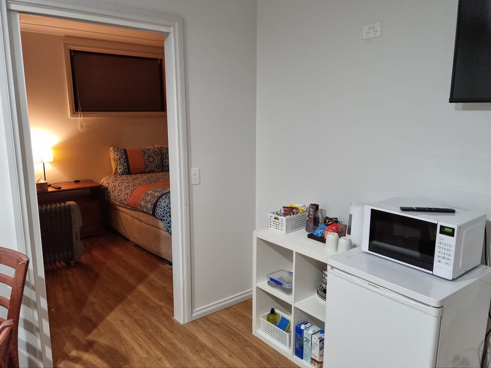 Main sitting room with mini fridge, HDTV and kettle and microwave 
