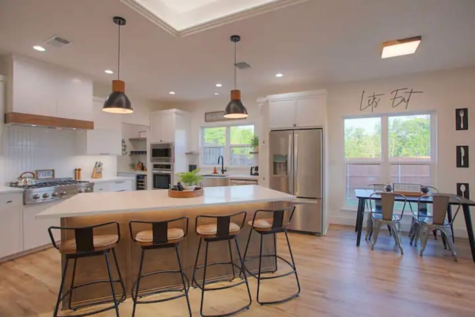 The modern is kitchen equipped with stainless steel appliances and ample seating