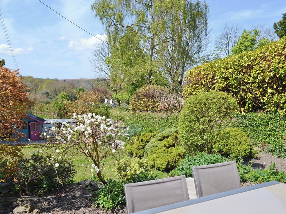 Sitting out area overlooking mature garden | Bee Bowl Cottage, Landcross, near Bideford