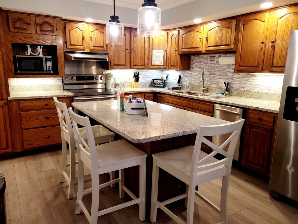 Kitchen with granite countertops and full suite of appliances, island seating