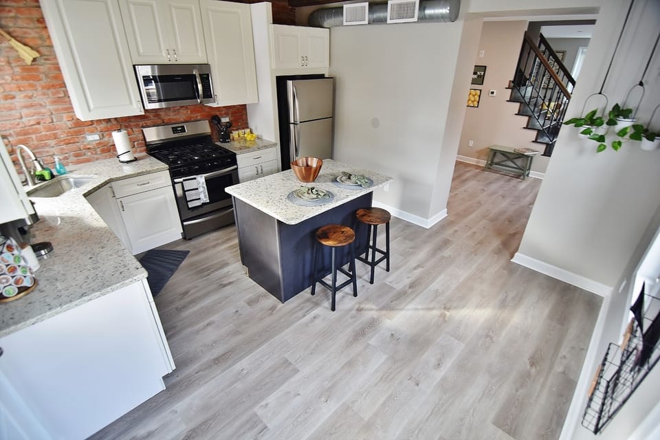 Enjoy cooking in this kitchen, which includes a dishwasher, a sleek stove and oven, a refrigerator with an ice maker, and a microwave. 
