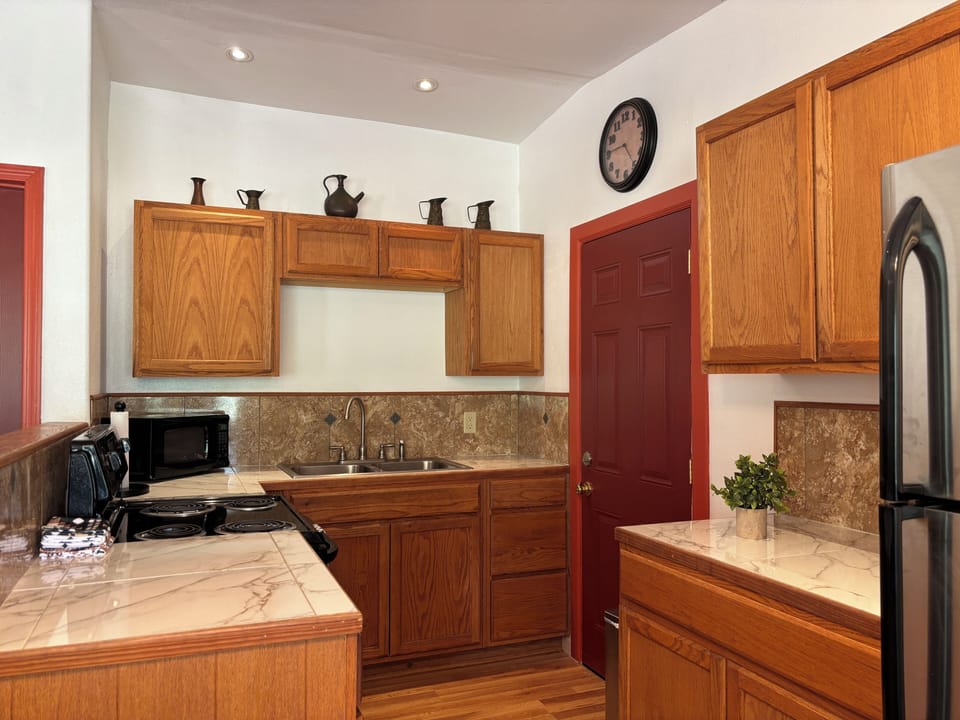 The kitchen with an oven, a full fridge, and plenty of counter space.