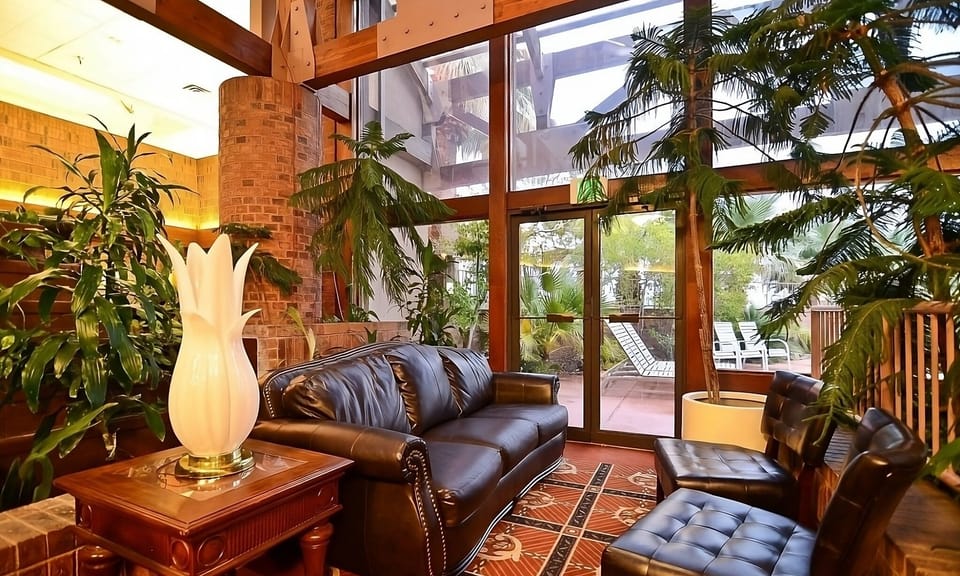 Unwind beneath soaring windows surrounded by lush indoor greenery.