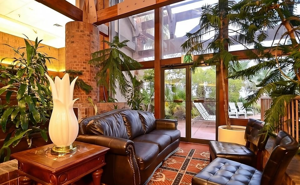 Unwind beneath soaring windows surrounded by lush indoor greenery.