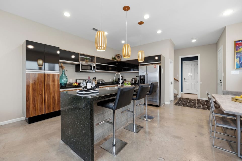 Kitchen with all essentials: microwave, double-door fridge, stove, oven, dishwasher, coffee station, and ample storage.