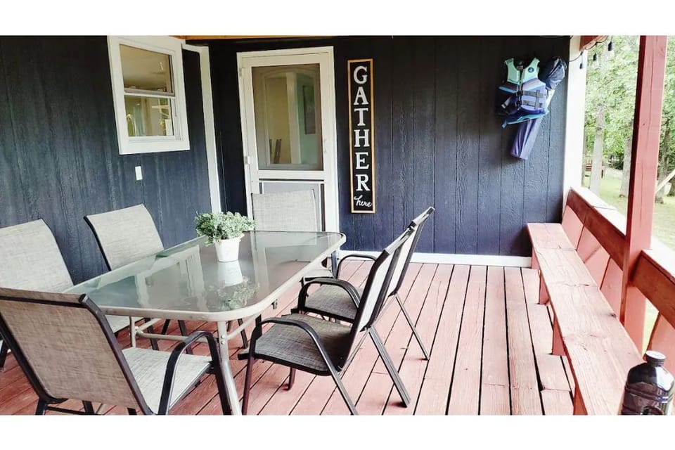 Covered porch with eating area and a lake view