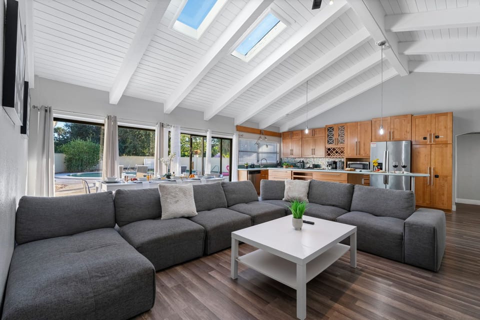Enjoy natural light streaming through skylights in this open living area — perfect for lounging or movie nights with family and friends.