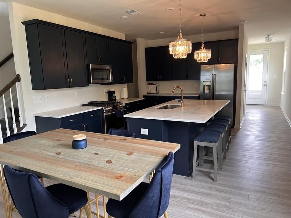 Quartz kitchen island, counter height table and stainless steel appliances