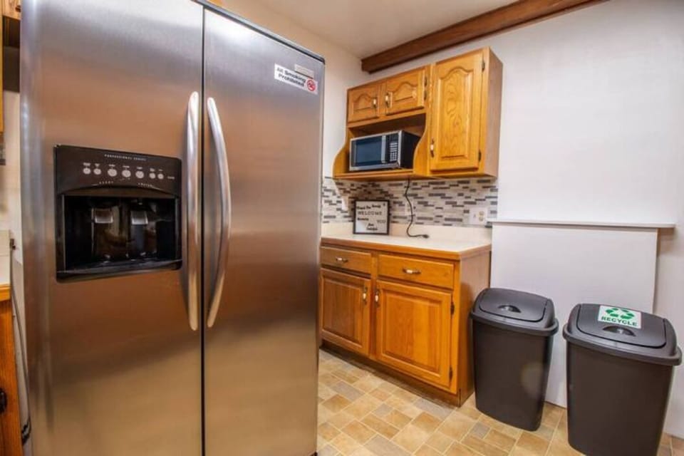 kitchen with four-place stove, kettle, coffee maker, large refrigerator and elegant cabinetry