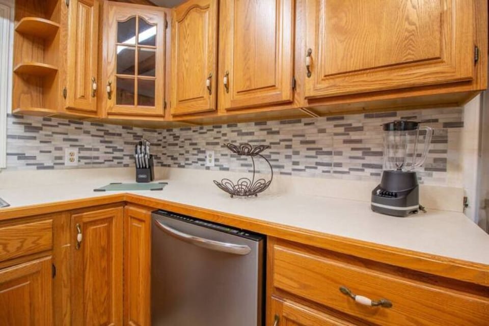 kitchen with four-place stove, kettle, coffee maker, large refrigerator and elegant cabinetry