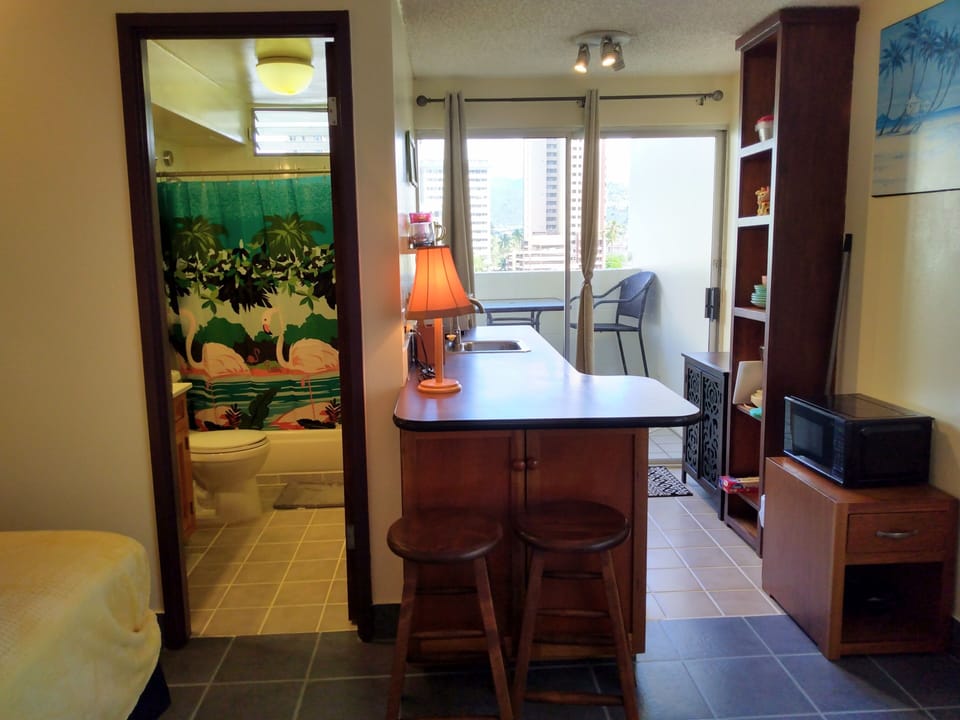 Bathroom entry, kitchen counter sitting area with 2 stools. 