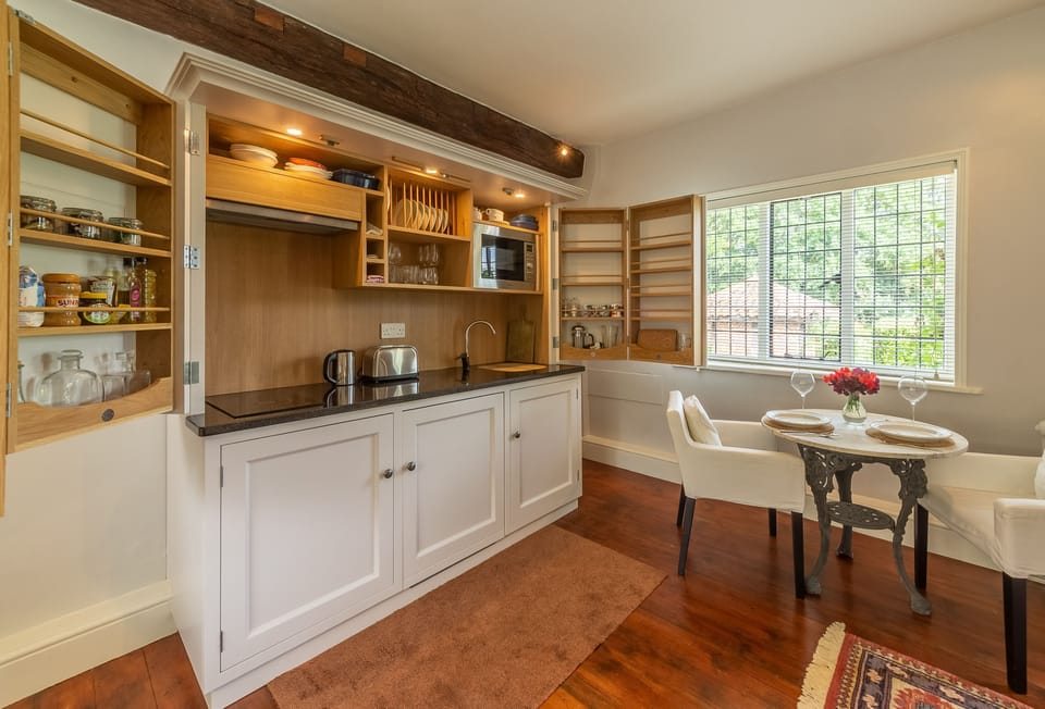 Ayres End Studio, Suffolk: Kitchen area conveniently hidden behind folding wooden doors