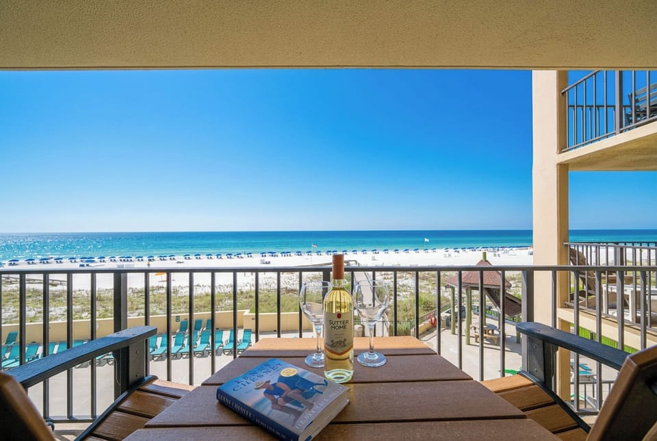 Savor a glass of wine while soaking in the stunning beach views from your cozy balcony retreat