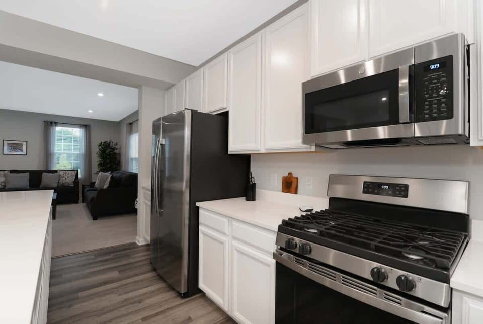 This elegant kitchen features stainless steel appliances, sleek cabinetry, and stunning countertops. The spacious layout, with a large island, is perfect for meal prep, casual dining, and hosting guests in a sophisticated, functional space.