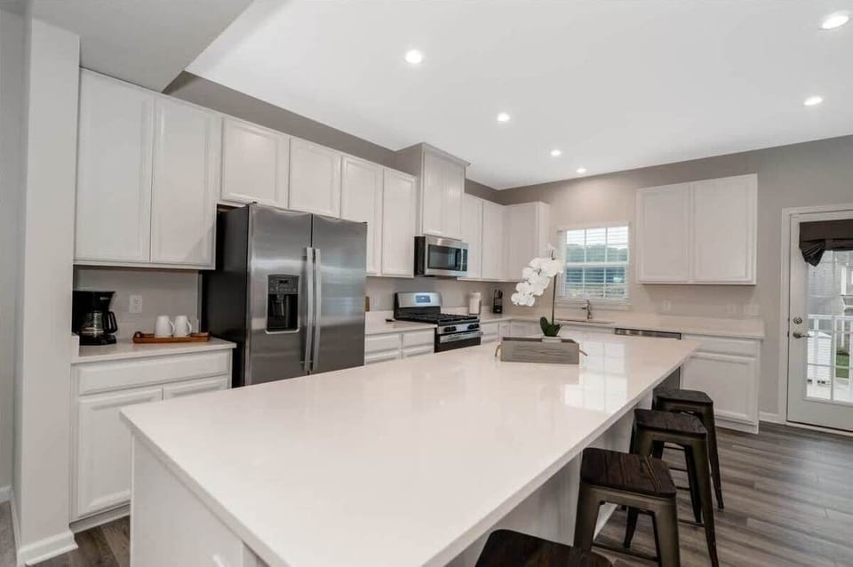 The large center island provides ample space for meal prep and casual dining, while the open floor plan allows for easy entertaining.