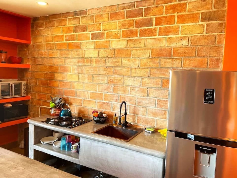The Full kitchen with handmade brick wall is original to the original Villa that was here. Full size fridge with ice maker, 4-burner gas stove, toaster oven, microwave, coffee maker, Hand hammered copper sink. All water is safe to drink from the taps