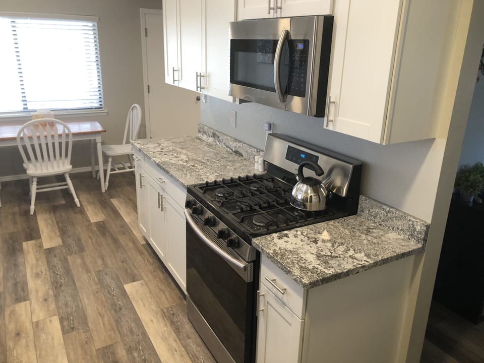 Kitchen with granite countertops, gas stove/oven and microwave 