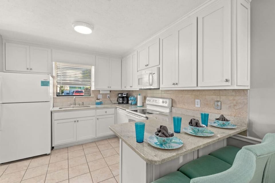 Fully-stocked kitchen with all appliances, cutely decorated with beach decor, ready for guest use! Breakfast bar seats 3.