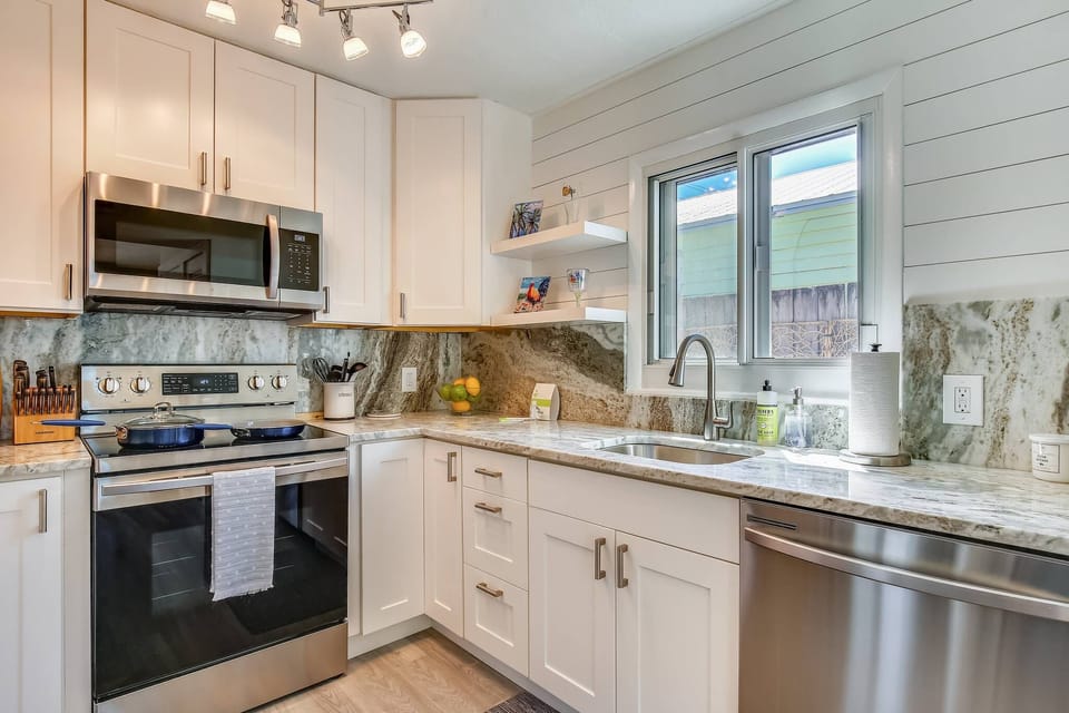 Sleek kitchen features modern appliances and marble countertops.
