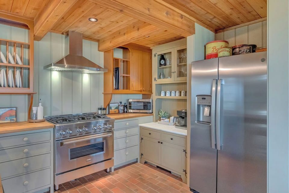 fully stocked kitchen with coffee bar on antique hutch and gas range