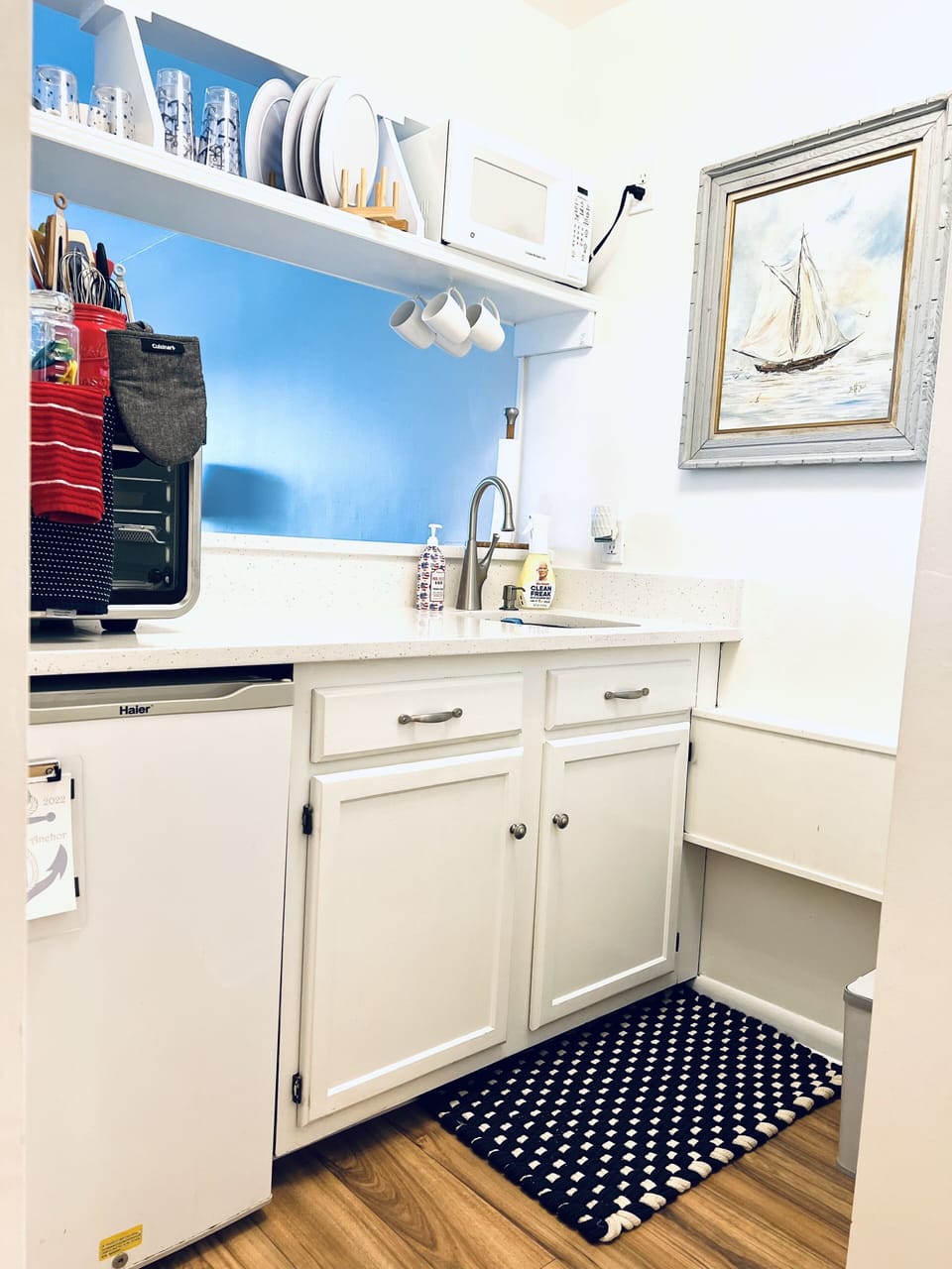 Sink, plates, glasses and Microwave above bar sink