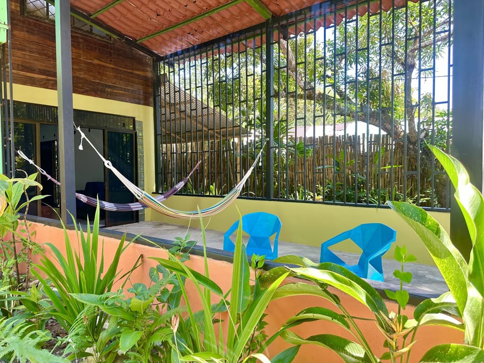 Covered patio with table, chairs and hammocks.