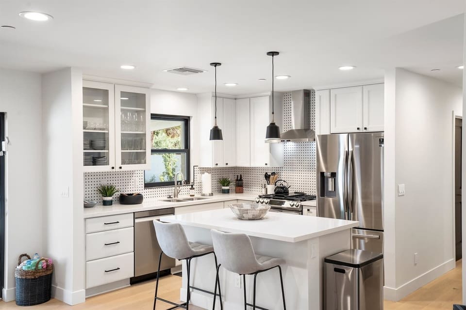Experience comfort and entertainment in the living room, featuring a spacious sectional couch, a TV with soundbar, and a coffee table, ideal for casual lounging and movie nights.