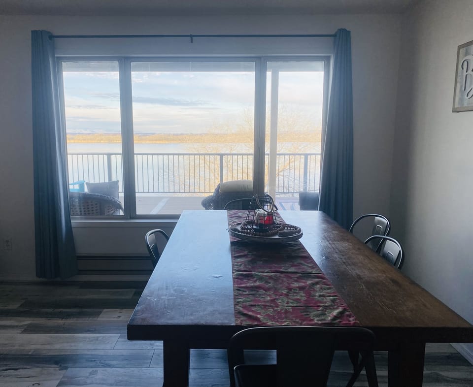 Dining area in living room with beautiful lake view.