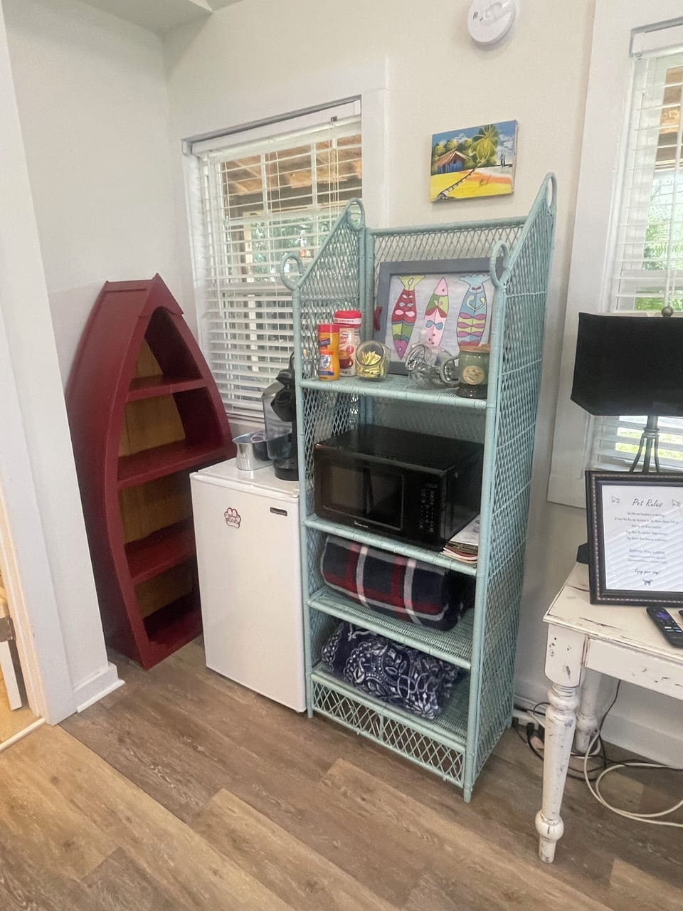 Has refrigerator, microwave, Keurig, and clothes storing on shelves. 