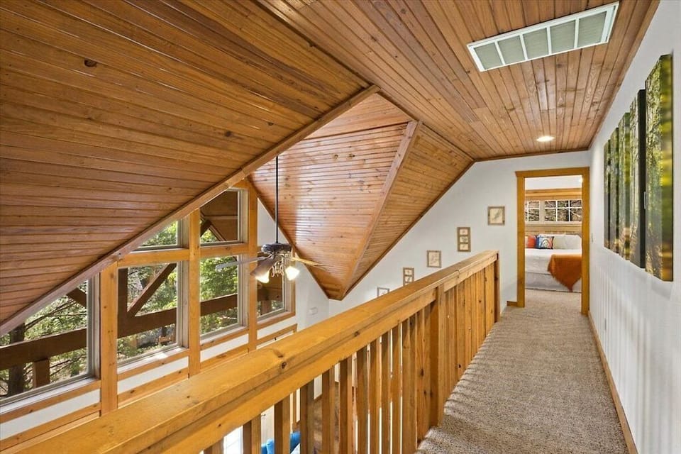Walkway upstairs between bedrooms surrounded by large windows and natural  light