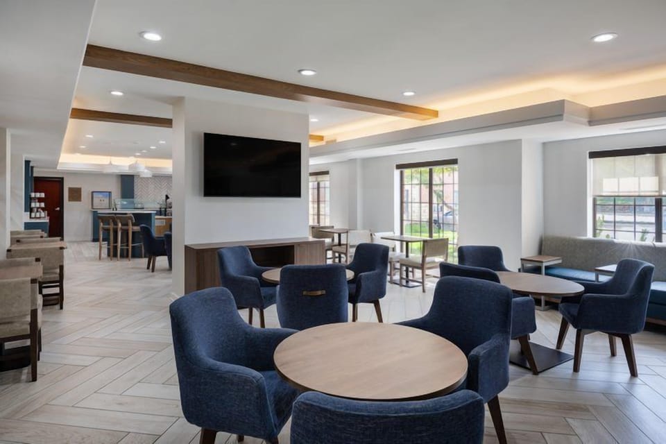 Round tables and blue upholstered chairs fill this lounge area for breakfast or casual seating.
