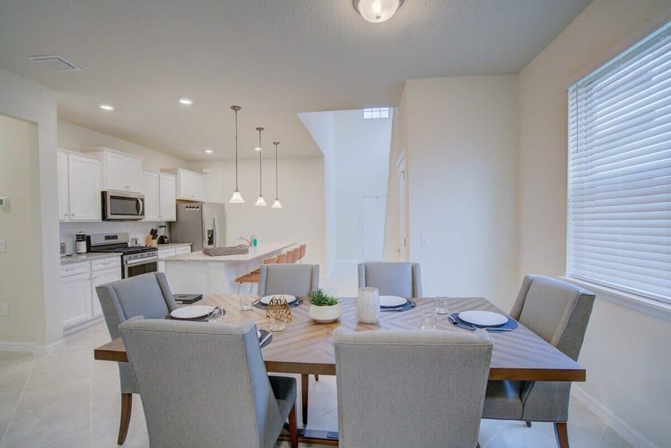 Elegant dining area with modern kitchen, perfect for family gatherings and gourmet meals.