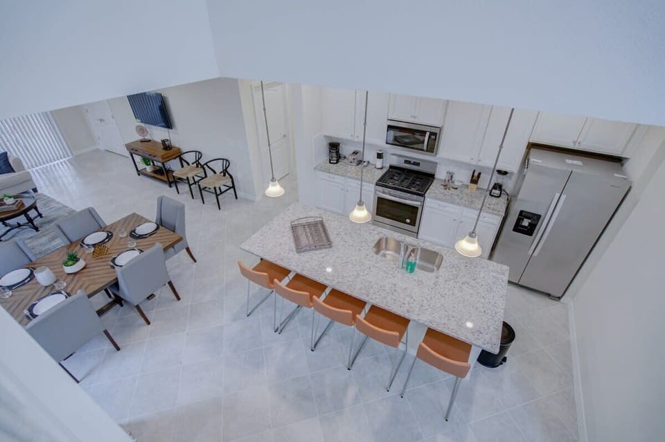 Spacious kitchen with granite island and dining area, perfect for entertaining and family gatherings.