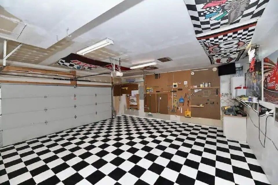 It took 25 hours to hand paint this race-themed b&w checkered flag garage floor.