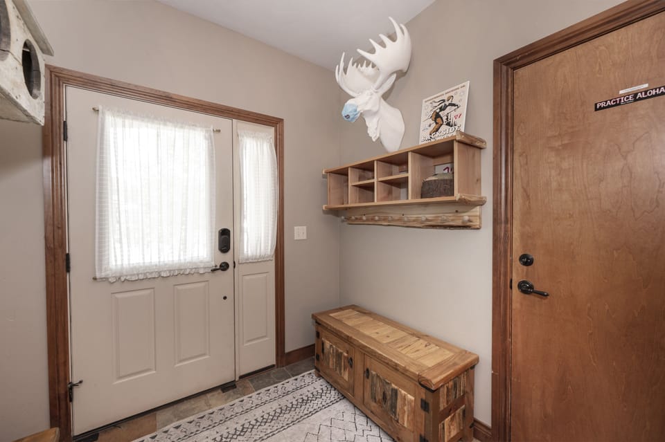 - Entryway with rustic wood bench and storage shelf   - Cozy mountain-style decor featuring antler accent   - Welcoming space to drop gear after outdoor fun