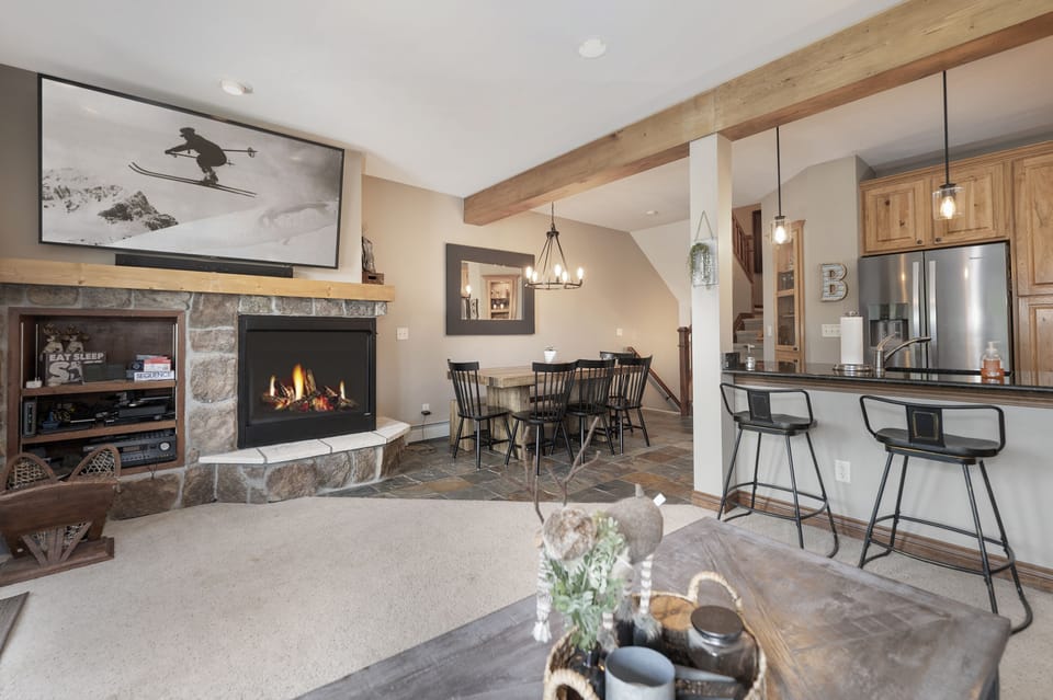 - Living area with fireplace and open dining layout   - Rustic beams and cozy decor enhance mountain charm   - Great space to gather with family and friends indoors