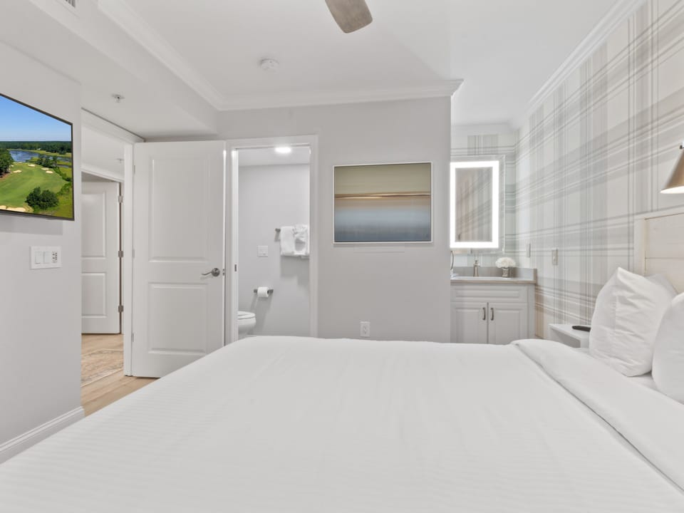 Wake up in your serene retreat with crisp white linens, an ensuite bathroom, and peaceful artwork creating the perfect sanctuary for rest.
