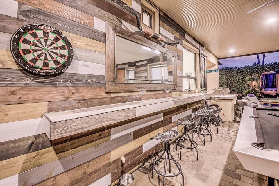 Outdoor bar/pool table area has access to the kitchen through the window