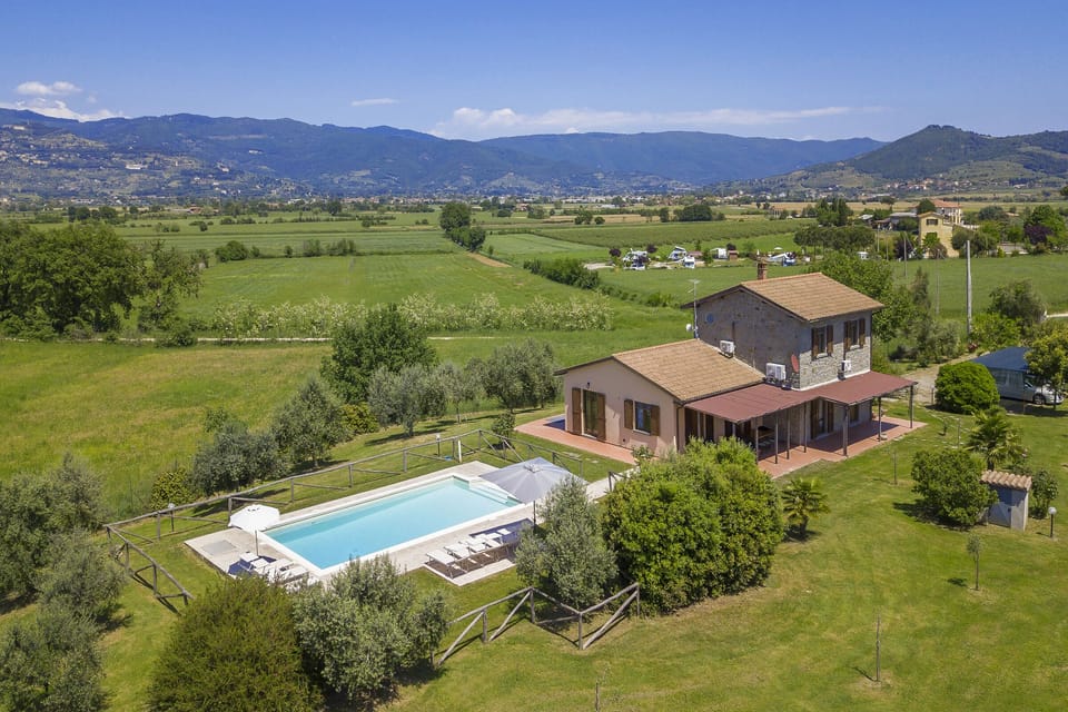 The property and the equipped pool surrounded by the well kept lawn