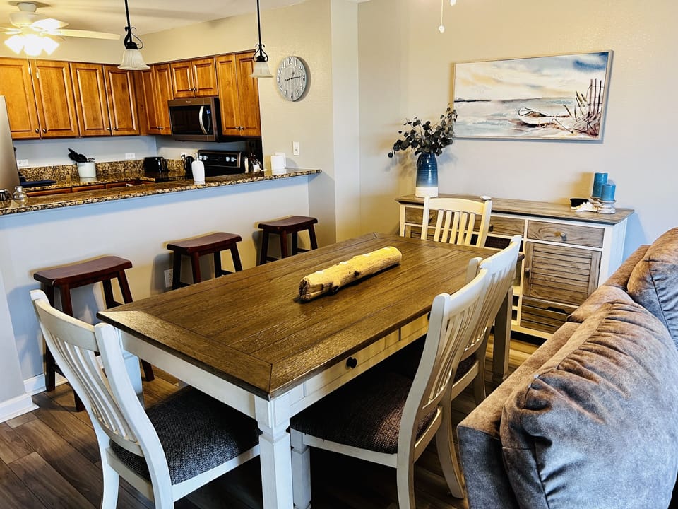 Gather around your spacious dining table where coastal charm meets comfort, with the full kitchen ready for memorable meals together.