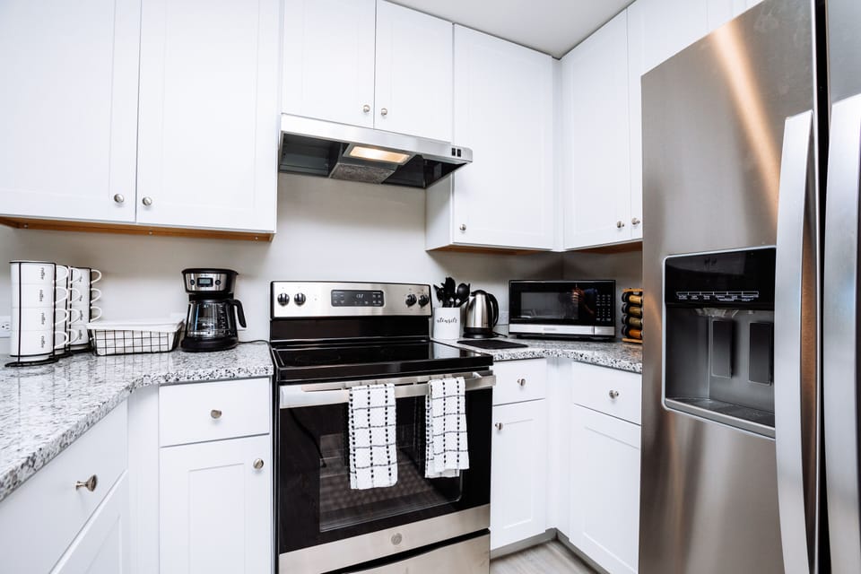 Modern kitchen is fully stocked and furnished with stainless steel appliances