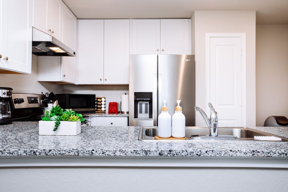 Modern kitchen is fully stocked and furnished with stainless steel appliances