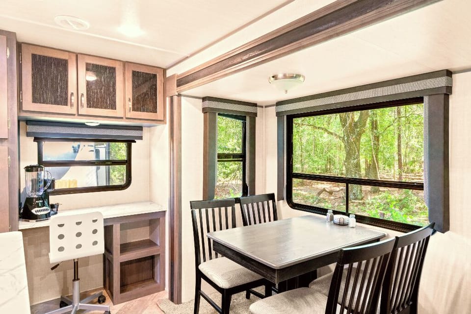 The Moto Ranch at Croom Vacation rental MX rv trailer. one bedroom 1 full bath sleeps 3. full kitchen with island sink, fridge and freezer, coffee maker, microwave, propane stove and oven, hood vent, dining table, reclining sofa chairs, retractable tv, small desk and chair