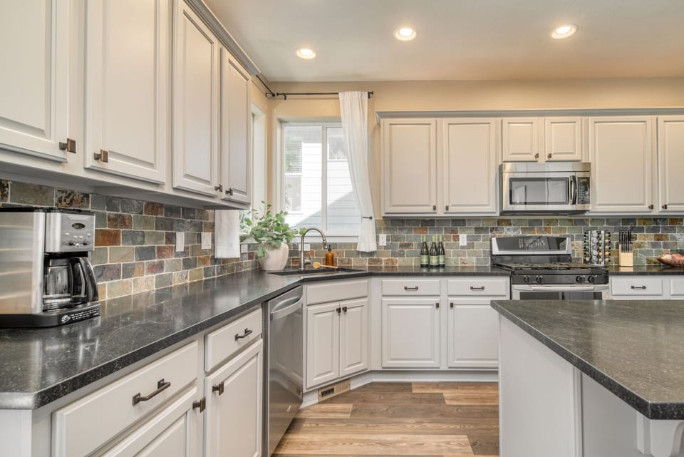 Modern appliances, including a microwave, dishwasher, stove, and coffee machine.